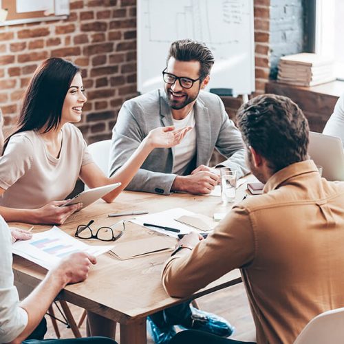 a workforce sitting around a desk discussing strategies