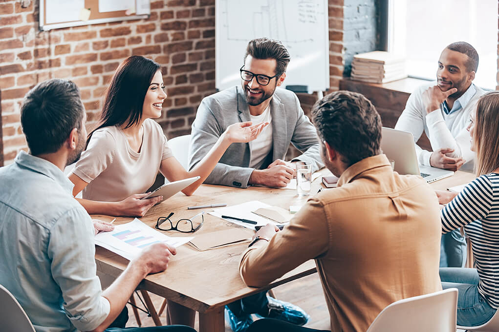 a workforce sitting around a desk discussing strategies